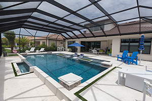 Lounge in style and comfort with a pair of shaded pool loungers. Like this elegant Florida setup, relaxation can begin in your own backyard.