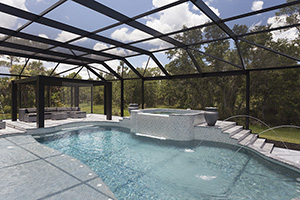 Your choice of pool shape sets the tone for your whole poolscape. This Florida homeowner chose a modern shape, combining sharp and rounded edges – establishing a theme that is echoed in the cool gray hardscaping – from the decking and coping to the fountain tile – and the ample gray lounge seating.