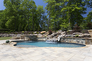 Natural stone features are a great option for a homeowner looking to incorporate the environment into their pool design. This beautiful pool features NPT StoneScapes Tahoe Blue pool finish and fantastic use of the local natural stone and travertine pavers.