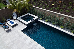 This contemporary California design has a deep blue pool finish accented with NPT’s Trident tile in Indigo. A glass bead fire pit, raised spa, and 6-foot wall with sheer descent waterfall heighten the elegant feel of the outdoor space.