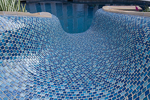 Vamp up the most fun part of your backyard - the waterslide! - with colorful pool tile like this NPT Soleil Cleo Blue 1x1 selection.