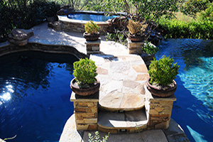 Want to create a natural-looking paradise in your backyard? Start with a freeform pool shape, then add organic design details like this stone bridge leading to a hidden raised spa.