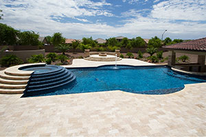 Lean into luxury with this geometric pool and custom wedding-cake style raised spa. NPT JewelScapes Yacht Club Blue pool finish perfectly suits the rich cobalt hues in the Jules Rustic Blue Blend tile.