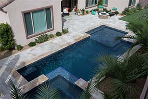 A geometric pool turns accessories into art. This pool features a negative edge spill over spa, a sheer descent waterfall, stacked stone and a putting green.