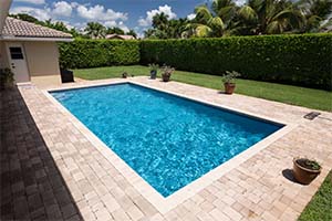 With an iconic rectangular shape and beautiful Tahoe Blue pool finish by NPT, this pool brings fun and excitement to a lush, landscaped backyard.