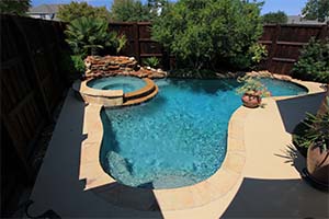 Curves and beautiful colors make a pool you can't wait to jump into. The kidney shape and beautiful decking give a natural feel, all topped off with a gorgeous raised attached spa.