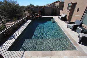 It's hard to beat a tried-and-true classic. A rectangular pool with travertine decking and coping looks great with a NPT Tahoe Blue finish.