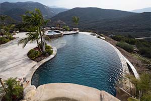 There's no place like home with this gorgeous freeform pool. Decorated in NPT's Black Mini Pebble, the pool features a Grotto, spa, swim-up bar, outdoor grill area and stunning infinity edge.